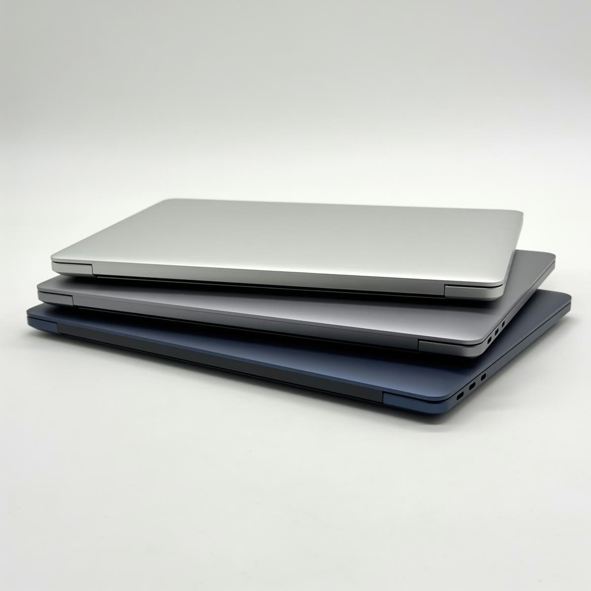 Mehrere Notebooks in Silber, Grau und Navy, gestaffelt angeordnet